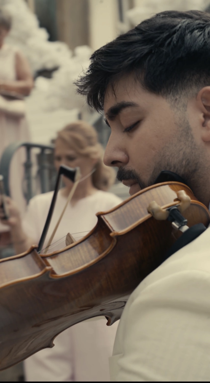 Gabriel Bonculescu performing violin to a group of guests